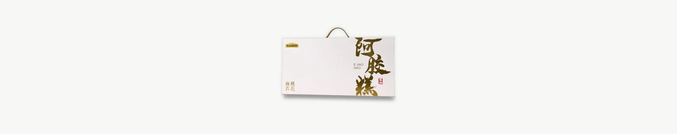 White gift box with gold hot-stamped lettering and rope handle for a food brand